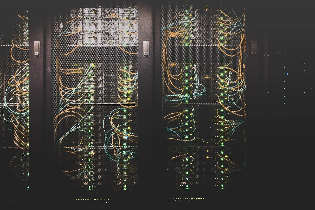 Server room corridor with network cables—generic editorial imagery for infrastructure security; not a specific CVE diagram.