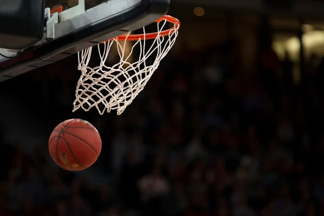 Indoor basketball arena lights and empty seats—generic editorial metaphor for NBA offseason roster speculation; not the Lakers, Crypto.com Arena, or LeBron James.