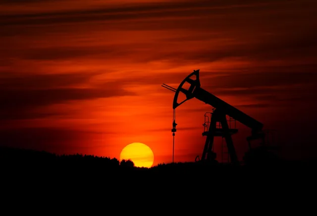 Industrial oil refinery silhouette at sunset — illustrative imagery of the global crude-oil supply chain whose pricing on the Monday May 11, 2026 Asian open jumped roughly three dollars a barrel after Washington's rejection of Iran's ceasefire reply and the continued near-closure of the Strait of Hormuz.
