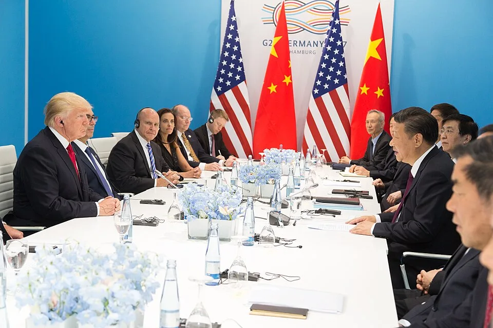 Donald Trump and Xi Jinping shaking hands at the G20 in Hamburg in July 2017—an archival photo of a prior meeting, not the 2026 Beijing summit.